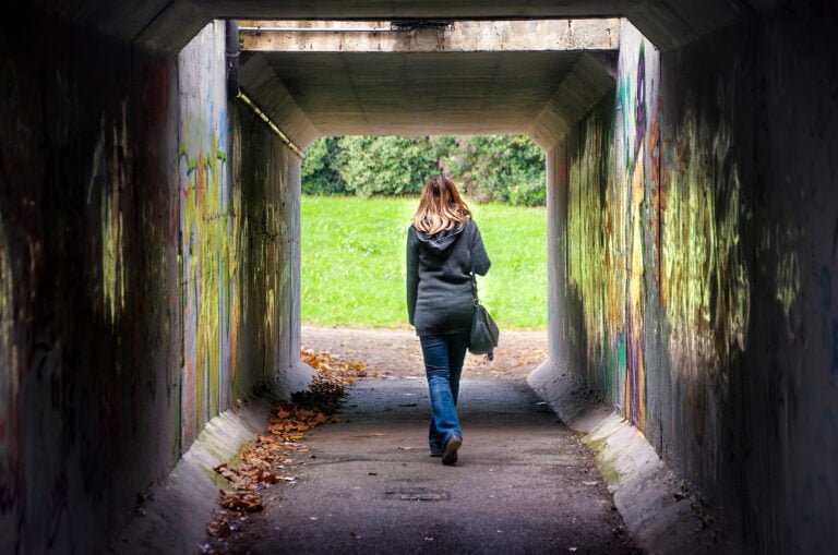 woman walking alone through a tunnel
